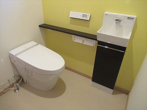 黄色の壁紙がアクセントなトイレ
